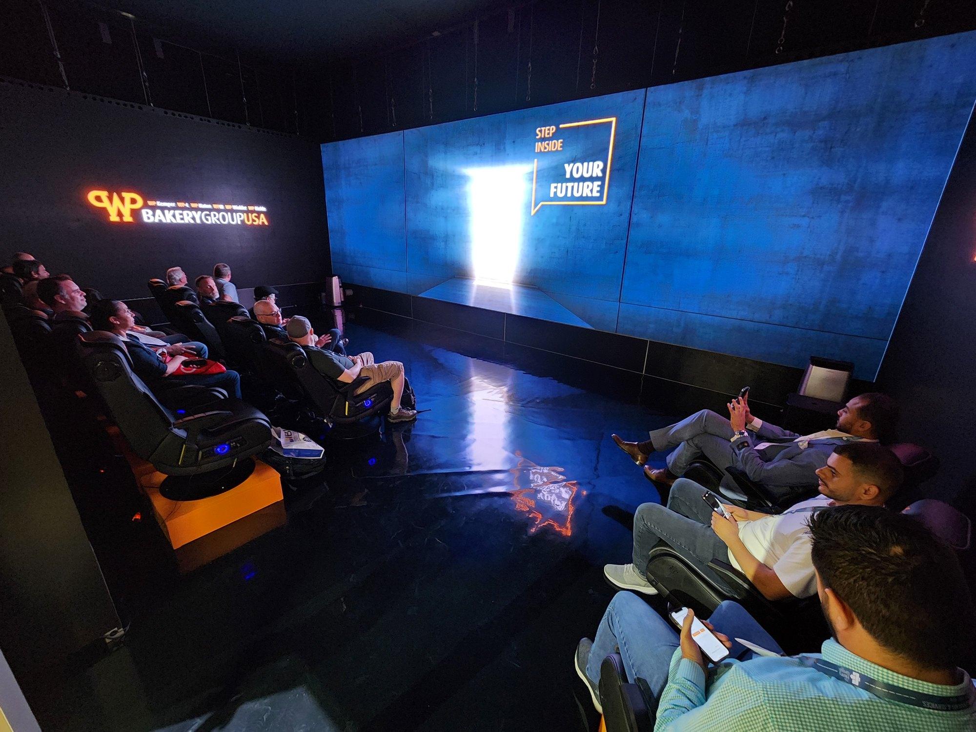 The LED Theatre: A seated room built out of four flown LED walls at IBIE 2022 - 356 tiles, a door cut through the screen, and twelve seats each on their own audio feed.