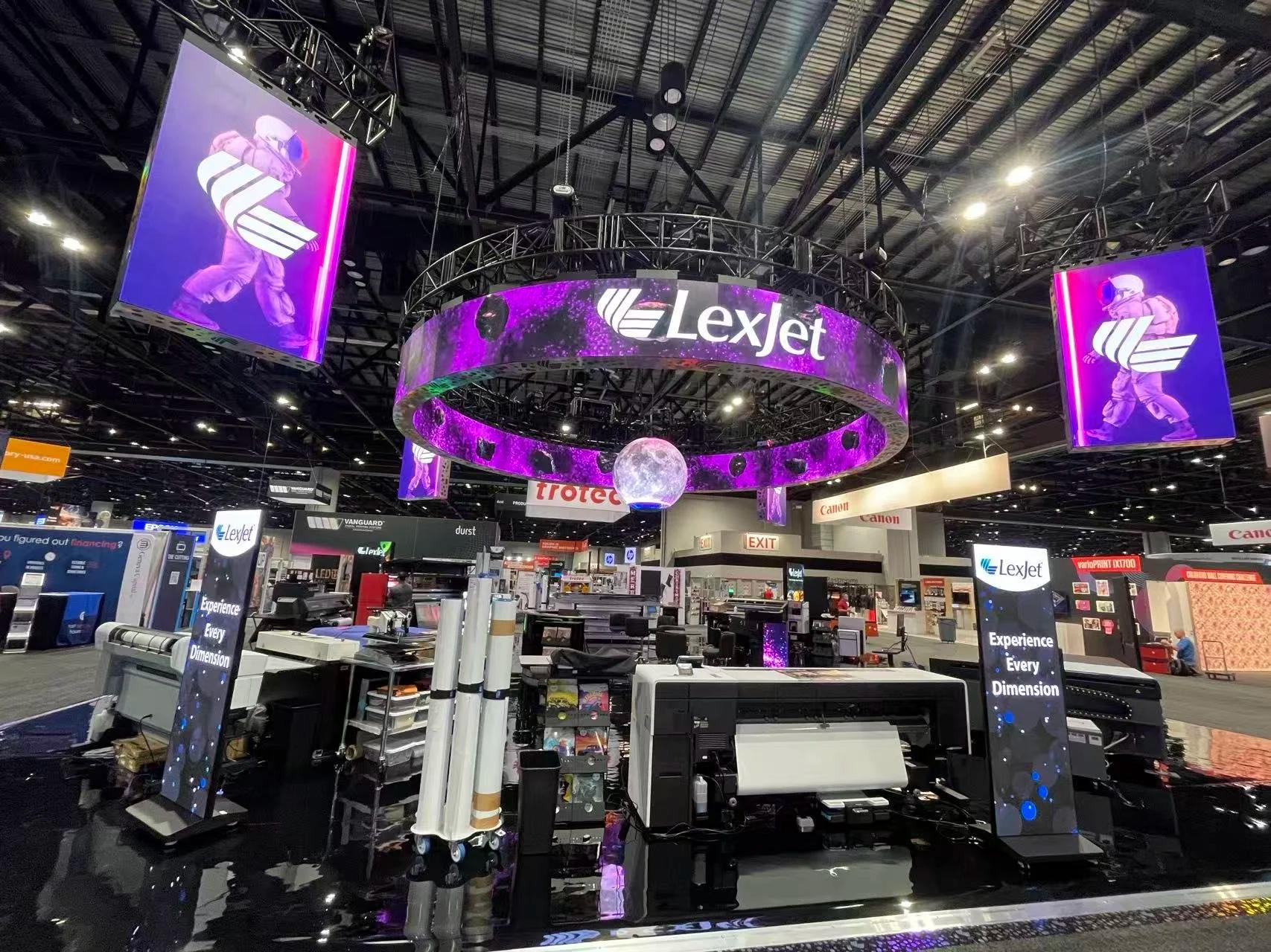 LexJet at Printing United: Two LED rings rigged back-to-back, four flown cardinal walls, a floating sphere and an LED counter, all on one synchronized 360° canvas.